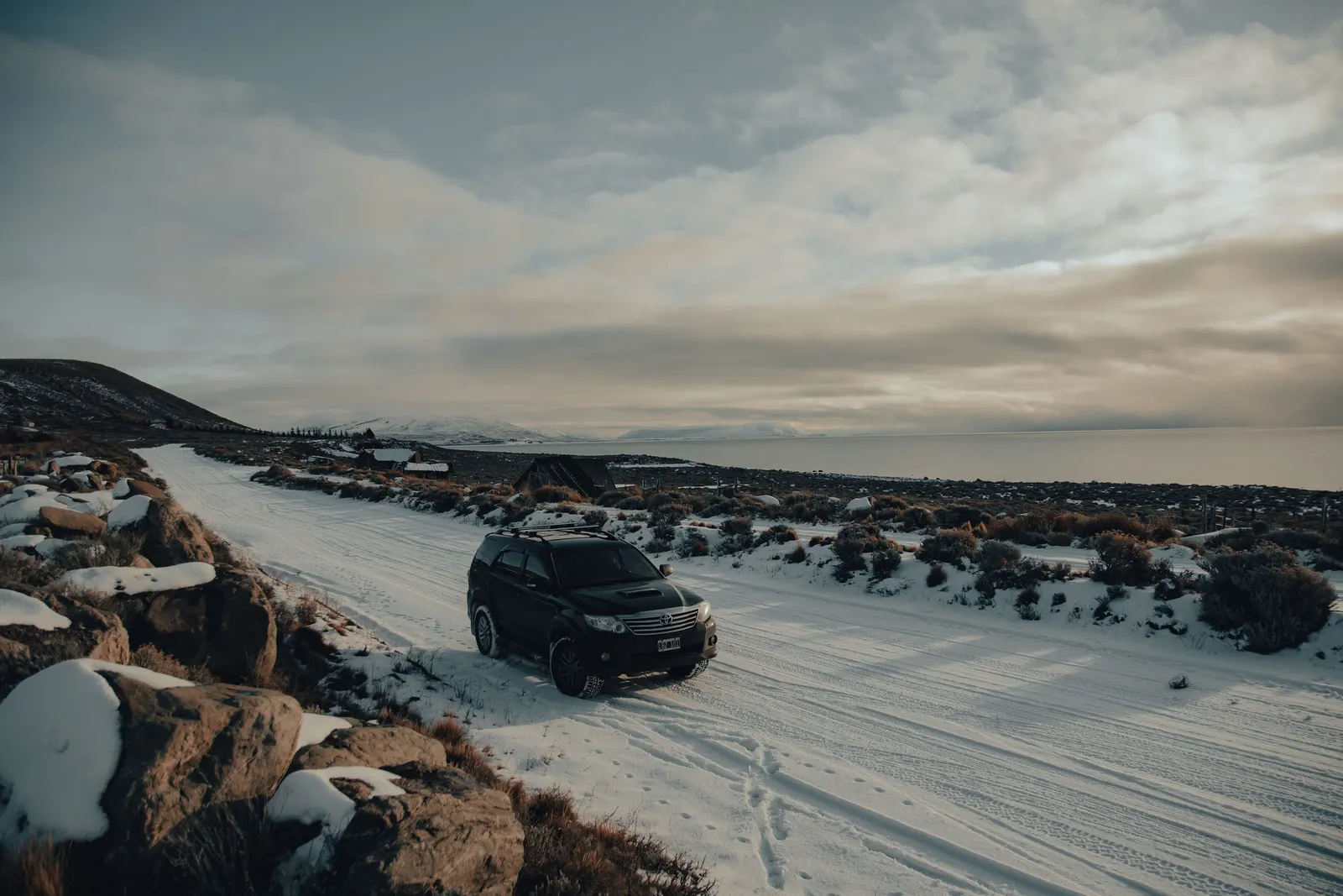 Allrad-SUV auf verschneiter Straße in winterlicher Berglandschaft