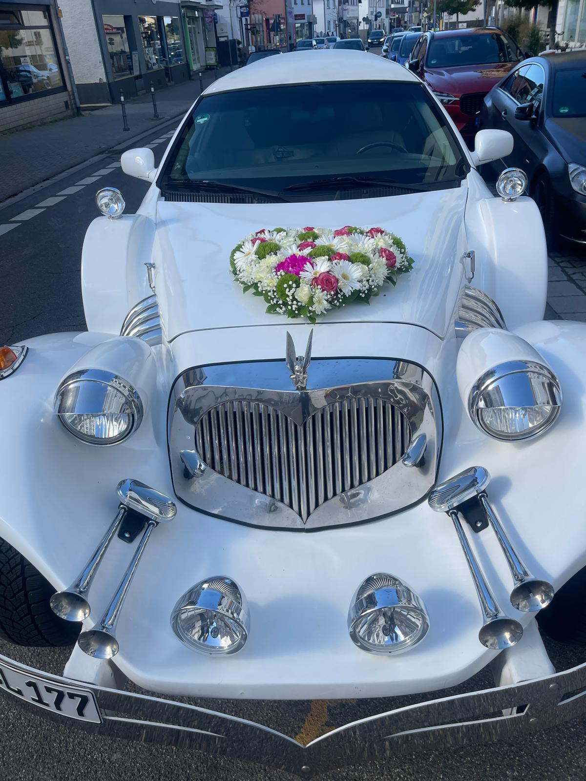 Excalibur Oldtimer Stretchlimousine in Weiß mit rotem Teppich und einer Sektflasche – 4
